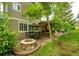 Cozy patio with a stone fire pit, dining set, and lush green landscaping at 9301 Lark Sparrow Dr, Highlands Ranch, CO 80126