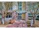 Inviting building entrance is surrounded by trees, featuring a sheltered walkway and glass doors at 2958 Syracuse St # 316, Denver, CO 80238