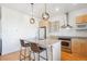 Contemporary kitchen island with seating, stainless steel appliances and stylish hanging light fixtures at 2958 Syracuse St # 316, Denver, CO 80238