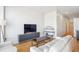Open-concept living room with stylish entertainment center, hardwood floors, comfortable seating, and modern decor at 2958 Syracuse St # 316, Denver, CO 80238
