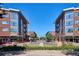 Street view with attractive brick apartment buildings and inviting storefronts below at 2958 Syracuse St # 316, Denver, CO 80238