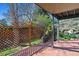 Covered deck with wood flooring, a view of greenery, and a wood retaining wall at 6969 W Yale Ave # 81, Denver, CO 80227