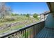 Balcony view features a grassy area enclosed by a rustic wooden fence and rock wall under a clear sky at 6969 W Yale Ave # 81, Denver, CO 80227