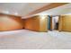 Finished basement with carpet, recessed lighting, orange accent wall, and access to stairs at 6969 W Yale Ave # 81, Denver, CO 80227