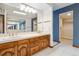 Bathroom with a double sink vanity, bright lighting, and blue accent wall at 6969 W Yale Ave # 81, Denver, CO 80227