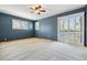 Spacious bedroom with blue accent wall, ceiling fan, carpet, and sliding glass door with shutter blinds at 6969 W Yale Ave # 81, Denver, CO 80227
