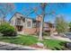 Beautiful home exterior with manicured lawn, mature trees, and brick and gray siding at 6969 W Yale Ave # 81, Denver, CO 80227