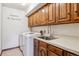 Laundry room with washer, sink, wood cabinets, counter space and 'Laundry & Dog Wash' wall decor at 6969 W Yale Ave # 81, Denver, CO 80227