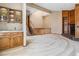 Open-concept living room featuring a fireplace, wet bar, staircase, and neutral carpeting at 6969 W Yale Ave # 81, Denver, CO 80227