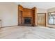 Cozy living room showcasing a fireplace with built-in shelving and plush carpeting at 6969 W Yale Ave # 81, Denver, CO 80227