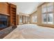 Living room showcasing a fireplace with built-in shelving, and multiple windows offering natural light at 6969 W Yale Ave # 81, Denver, CO 80227