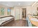Bathroom featuring double sinks, a soaking tub with mosaic accents, and an open doorway to a closet at 4825 6Th St, Boulder, CO 80304