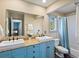 Bathroom featuring double sinks, a soaking tub with shower, and blue cabinets at 4825 6Th St, Boulder, CO 80304