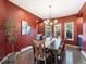 Elegant dining room featuring bold red walls, a chandelier, hardwood floors, and ample seating for dinner parties at 4825 6Th St, Boulder, CO 80304