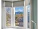 Window view of the tree tops with the mountain landscape in the background with natural sunlight at 4825 6Th St, Boulder, CO 80304