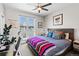 Stylish bedroom with a bed featuring decorative pillows, an adjacent desk, and large windows at 1215 N Perry St, Denver, CO 80204