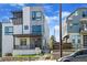 Contemporary three-story townhome featuring stone accents, covered porch, and a landscaped front yard at 1215 N Perry St, Denver, CO 80204