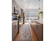A narrow galley kitchen features modern wood cabinets, stainless appliances and a runner along wood floors at 1215 N Perry St, Denver, CO 80204