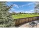 Backyard with a firepit, wooden fence, and views of the adjacent lush green golf course at 234 Cypress Cir, Broomfield, CO 80020