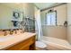 Bright bathroom featuring a bathtub with a shower, light wood vanity, and a mirrored cabinet at 234 Cypress Cir, Broomfield, CO 80020