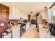 Modern kitchen featuring white cabinets, stainless steel appliances, and hardwood floors with a view into another room at 234 Cypress Cir, Broomfield, CO 80020