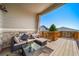 Covered back deck with comfortable seating, a glass table, and a view of the surrounding neighborhood at 17028 Osage St, Broomfield, CO 80023