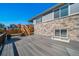 Back yard with a gray deck and steps leading down to the AstroTurf area, all surrounded by a wood fence at 17028 Osage St, Broomfield, CO 80023