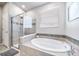 Bathroom showcasing tub with tile surround and a glass-enclosed shower at 17028 Osage St, Broomfield, CO 80023