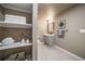 Cozy bathroom featuring decorative shelving, a vanity, toilet, and a well-lit mirror at 17028 Osage St, Broomfield, CO 80023