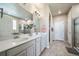 Bathroom featuring double sinks, walk-in shower, and tile floors at 17028 Osage St, Broomfield, CO 80023