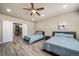 A spacious bedroom featuring two beds, a ceiling fan, a closet with sliding doors, and tasteful decor at 17028 Osage St, Broomfield, CO 80023