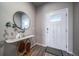 Entryway boasts stylish wood floors, white door, and a modern console table with circular mirror at 17028 Osage St, Broomfield, CO 80023