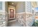 A welcoming covered front porch features stone accents, providing shelter and curb appeal at 17028 Osage St, Broomfield, CO 80023
