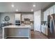 Modern kitchen boasts white cabinetry, stainless steel appliances, and a stylish backsplash at 17028 Osage St, Broomfield, CO 80023