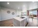 Open-concept kitchen with island, stainless steel dishwasher, and adjacent living area with patio access at 17028 Osage St, Broomfield, CO 80023