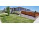 Well-maintained home exterior featuring lush green lawn and neutral stone accents, surrounded by wood fence at 17028 Osage St, Broomfield, CO 80023
