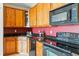 Close-up of kitchen with wood cabinets, black appliances, and dark countertops at 9481 E Mansfield Ave # 203, Aurora, CO 80014