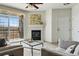 Bright living room featuring a fireplace, a balcony, and comfortable seating with artistic decor at 9481 E Mansfield Ave # 203, Aurora, CO 80014