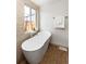 Stylish bathroom featuring a modern soaking tub, natural light from the window and neutral color palette at 4565 Elm Ct, Denver, CO 80211