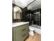 Modern bathroom boasts elegant black tile, a shower with glass doors, and contemporary fixtures at 4565 Elm Ct, Denver, CO 80211