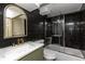 Contemporary bathroom featuring black tiled walls, glass shower, and sleek fixtures at 4565 Elm Ct, Denver, CO 80211