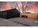 Detached two car garage with a long driveway and a wooden fence in the background at 4565 Elm Ct, Denver, CO 80211