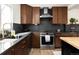 A full shot of a kitchen with stainless appliances, hardwood floors and dark stone backsplash at 4565 Elm Ct, Denver, CO 80211