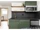 This kitchenette features chic green cabinets, stainless steel appliances, and sleek black marble countertops at 4565 Elm Ct, Denver, CO 80211