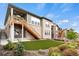 This backyard showcases a wooden staircase leading to a balcony, a charming garden, and a well-manicured lawn at 9130 Fraser River, Littleton, CO 80125