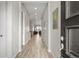 Long, bright hallway with wood-look flooring leading to an open living area at 9130 Fraser River, Littleton, CO 80125