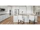 Spacious kitchen island featuring seating, modern appliances, and light wood-look floors at 9130 Fraser River, Littleton, CO 80125