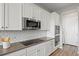 Modern kitchen boasts stainless steel appliances, sleek countertops, subway tile backsplash, and white cabinets at 9130 Fraser River, Littleton, CO 80125