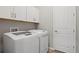 Convenient laundry room features modern washer and dryer set, and ample storage cabinets at 9130 Fraser River, Littleton, CO 80125