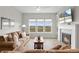 Cozy living room with fireplace, plush seating, large windows offering beautiful outdoor views at 9130 Fraser River, Littleton, CO 80125